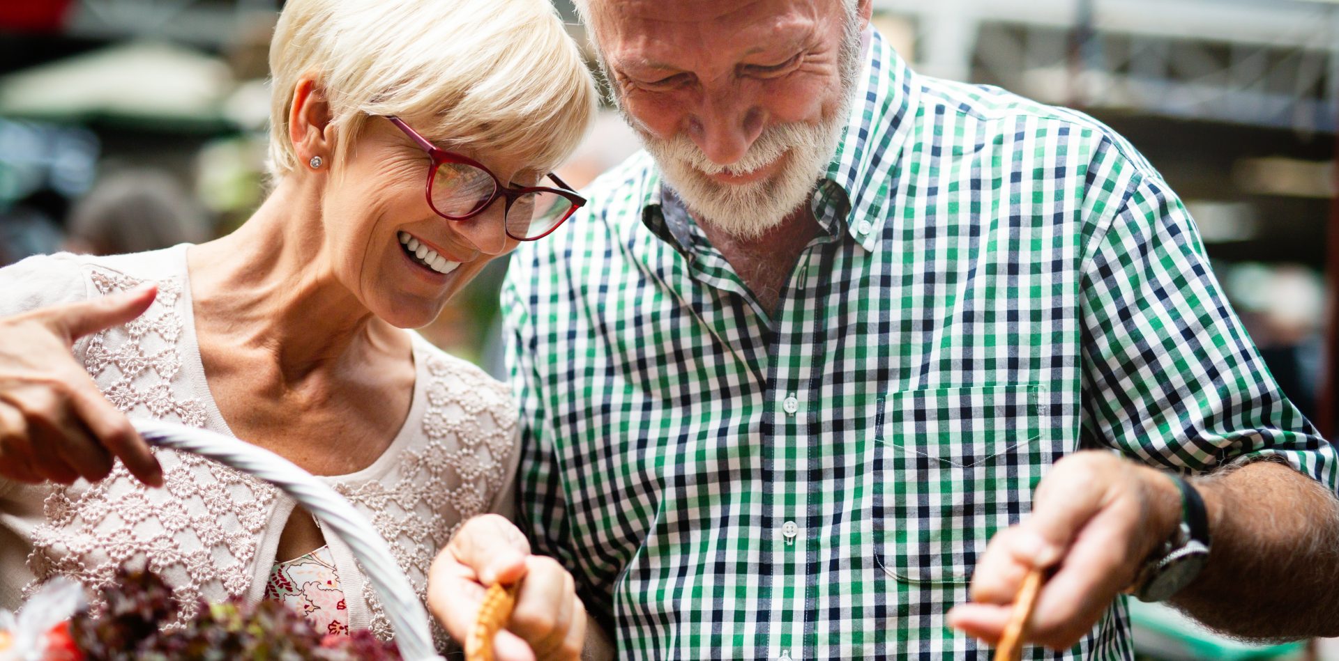 Portrait of beautiful elderly couple in market buing food