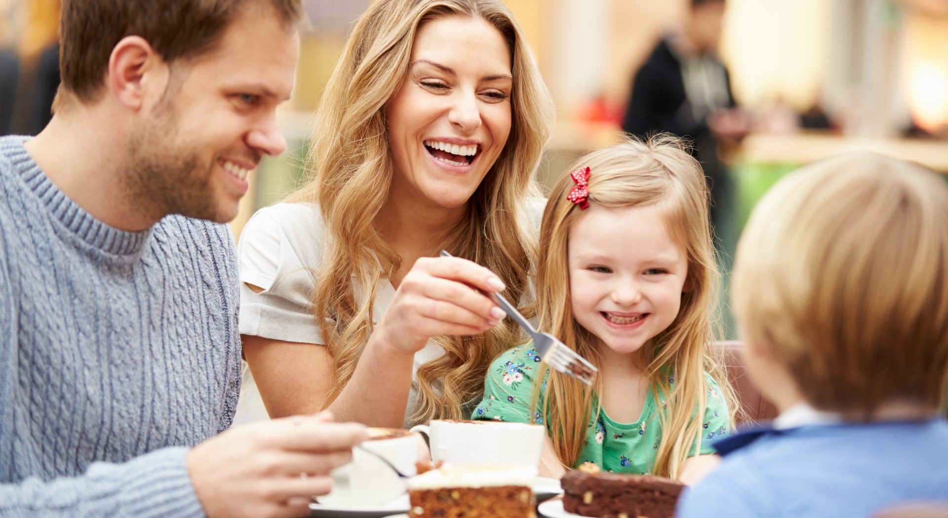 Family Enjoying Snack In Cafe Together